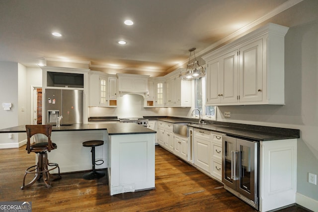 kitchen featuring sink, white cabinetry, stainless steel fridge, a kitchen island, and wine cooler