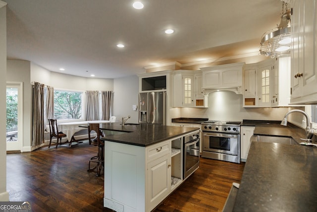 kitchen with sink, a kitchen island, white cabinetry, and appliances with stainless steel finishes