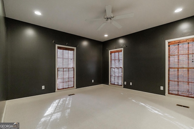 carpeted spare room with ceiling fan