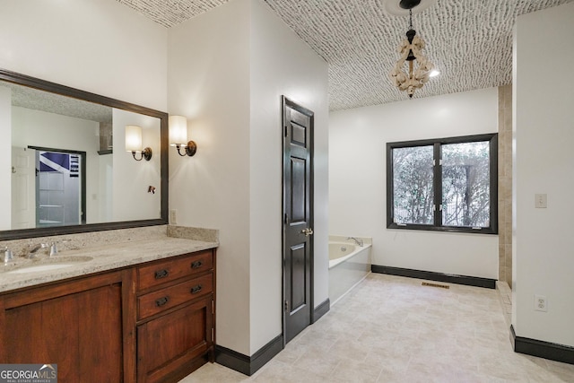 bathroom featuring an inviting chandelier, a tub to relax in, and vanity