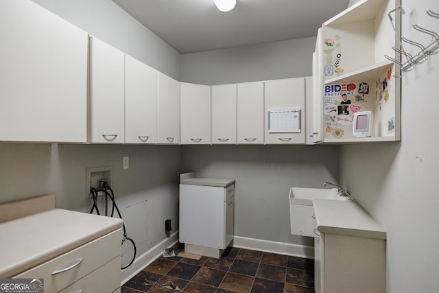 clothes washing area featuring washer hookup and cabinets