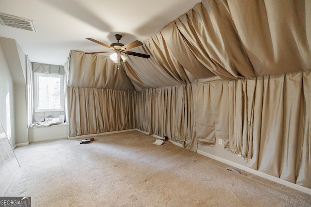 additional living space with ceiling fan and light colored carpet