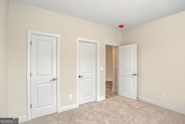 unfurnished bedroom with light colored carpet