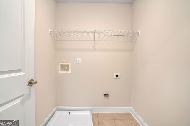 clothes washing area featuring electric dryer hookup, light tile patterned floors, and washer hookup