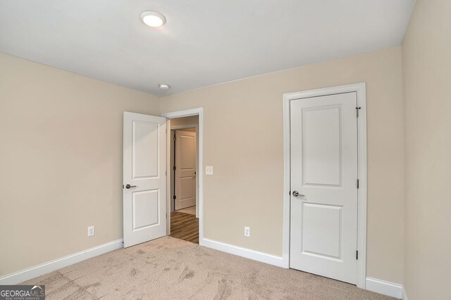 unfurnished bedroom featuring light carpet