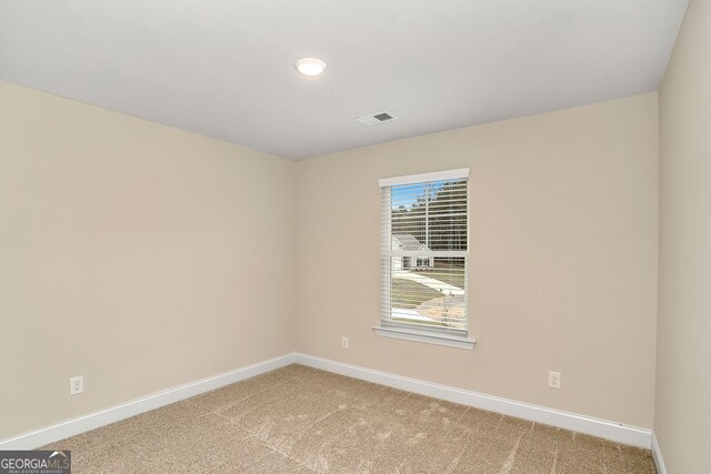 spare room featuring light colored carpet