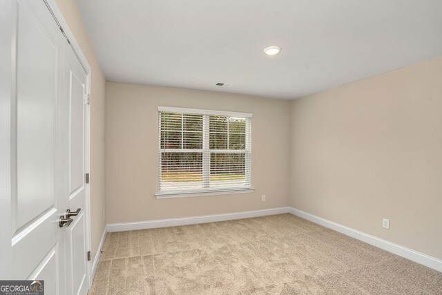 unfurnished room with light carpet