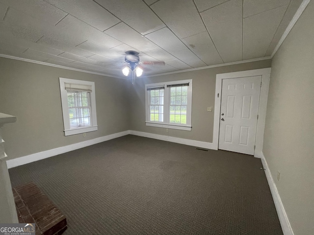 carpeted empty room featuring a wealth of natural light, crown molding, and ceiling fan