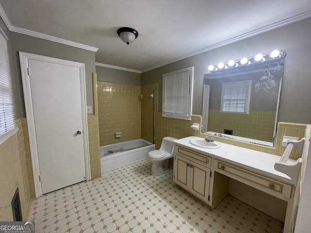 full bathroom with ornamental molding, vanity, tile walls, toilet, and tiled shower / bath