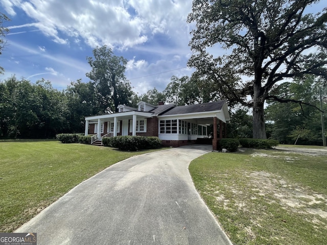 ranch-style home featuring a carport and a front yard