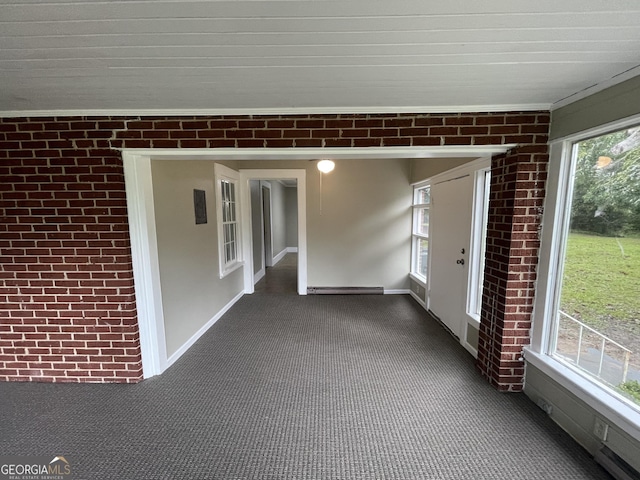 unfurnished sunroom featuring baseboard heating and a healthy amount of sunlight