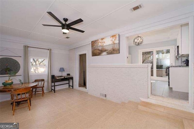 living area with plenty of natural light, visible vents, and ceiling fan with notable chandelier