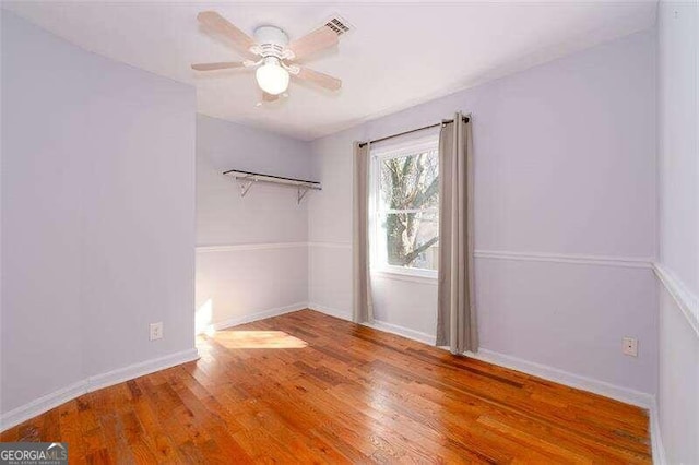 spare room featuring a ceiling fan, baseboards, and wood finished floors