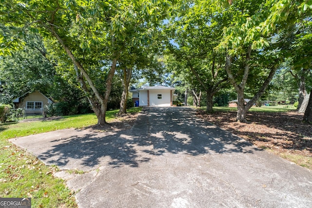 obstructed view of property with a front yard and driveway