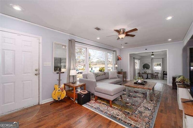 living area featuring recessed lighting, wood finished floors, a ceiling fan, visible vents, and ornamental molding