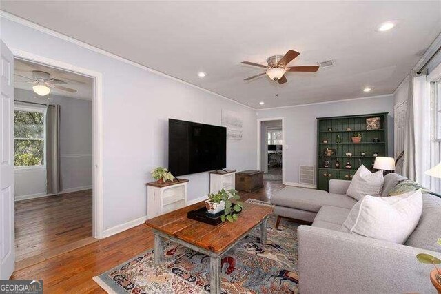 living room with hardwood / wood-style flooring and crown molding