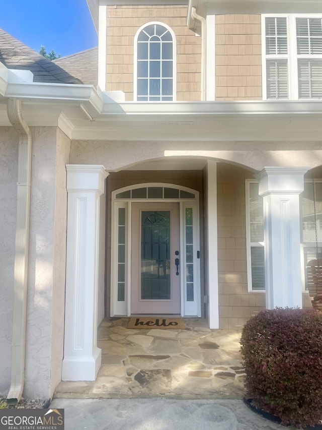 entrance to property with roof with shingles