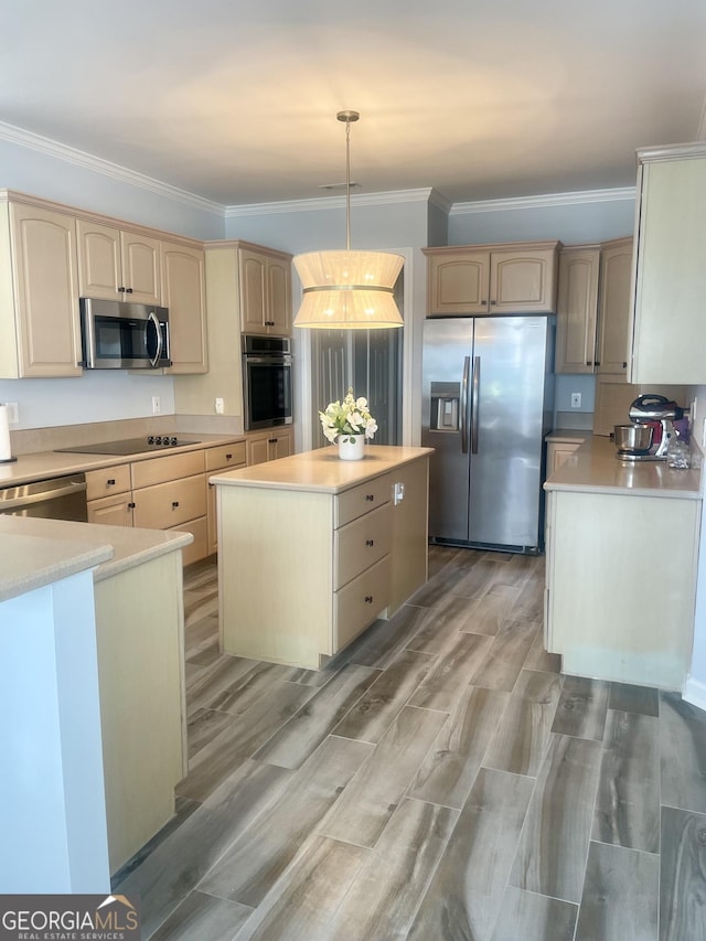 kitchen with light brown cabinets, a kitchen island, light countertops, appliances with stainless steel finishes, and decorative light fixtures