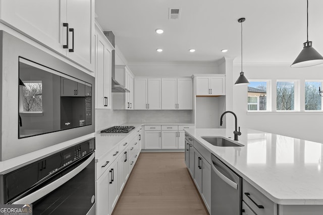 kitchen with sink, a center island with sink, white cabinets, and appliances with stainless steel finishes