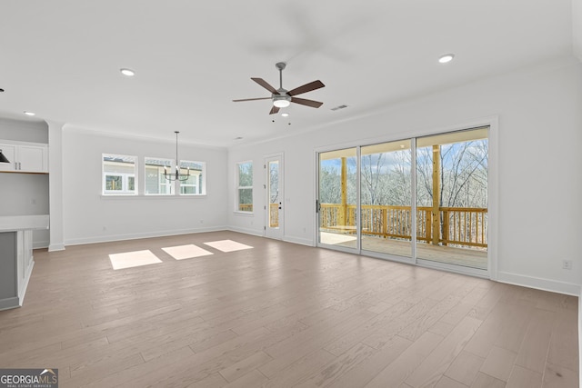 unfurnished living room featuring crown molding, ceiling fan with notable chandelier, and light hardwood / wood-style flooring