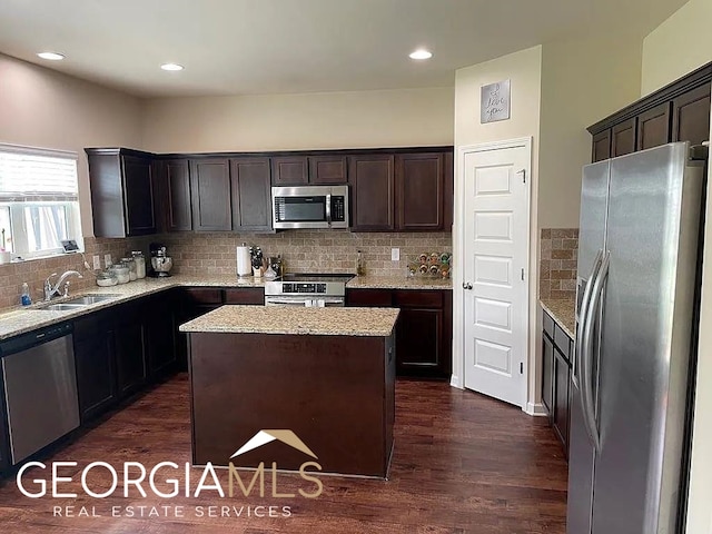 kitchen with backsplash, a kitchen island, dark hardwood / wood-style floors, stainless steel appliances, and sink