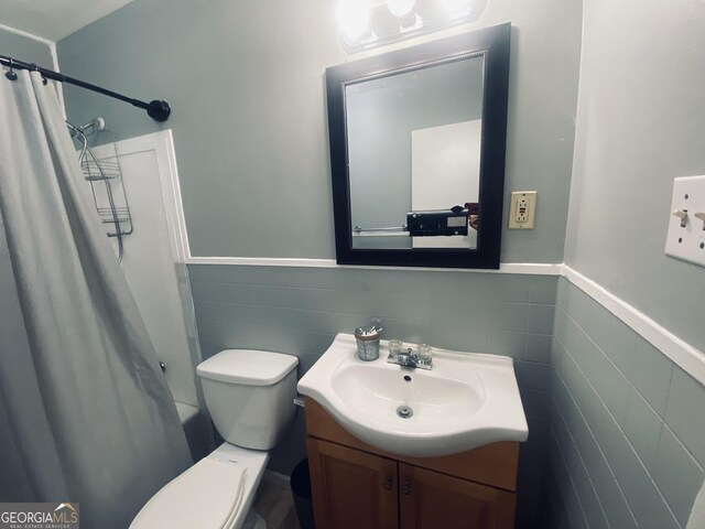 bathroom featuring vanity, backsplash, toilet, and tile walls