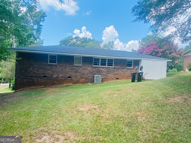 back of property featuring central AC unit and a yard