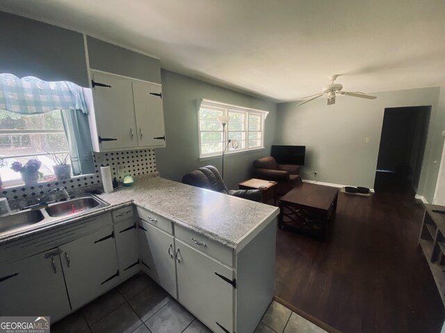 kitchen featuring tile patterned flooring, kitchen peninsula, ceiling fan, decorative backsplash, and sink