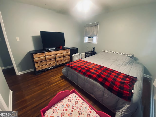 bedroom with cooling unit and dark wood-type flooring