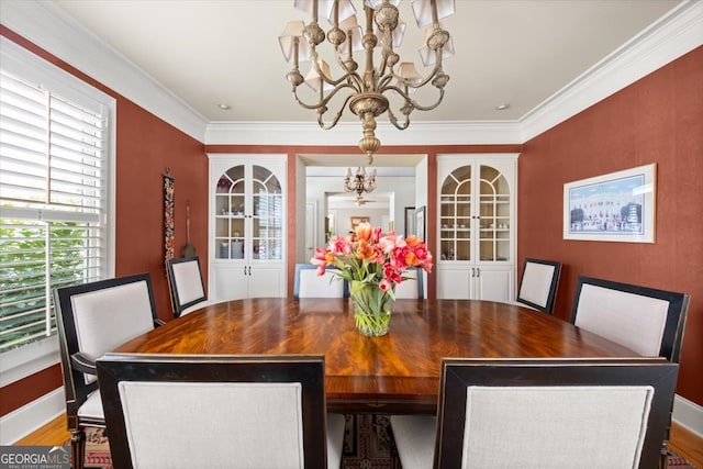 dining room with wood-type flooring, a notable chandelier, and crown molding