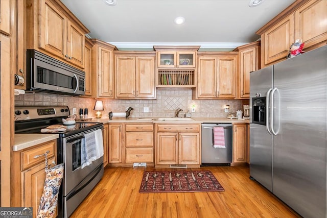 kitchen featuring light hardwood / wood-style floors, ornamental molding, and stainless steel appliances