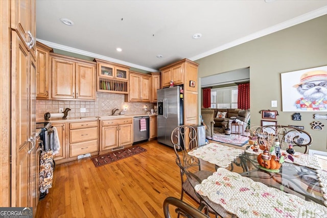 kitchen featuring stainless steel appliances, light hardwood / wood-style floors, and crown molding