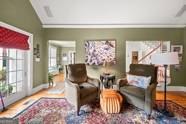 living area featuring light wood-type flooring, crown molding, and vaulted ceiling