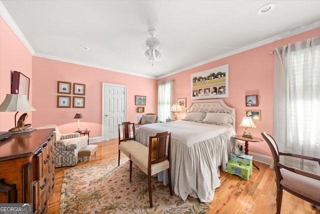 bedroom with light hardwood / wood-style floors, ornamental molding, and ceiling fan