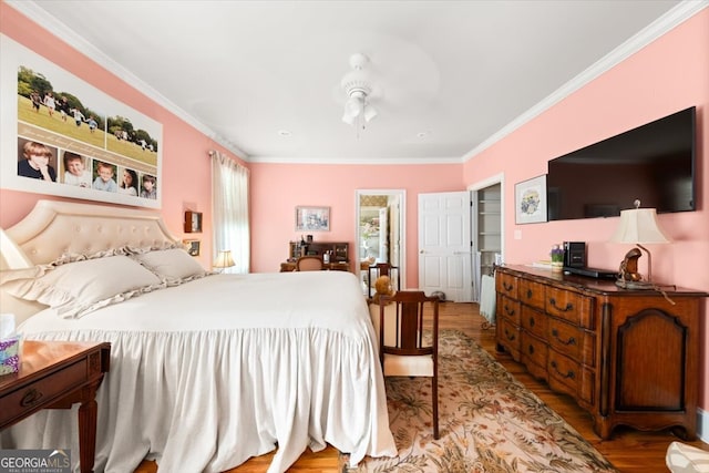 bedroom featuring wood-type flooring, ornamental molding, and ceiling fan