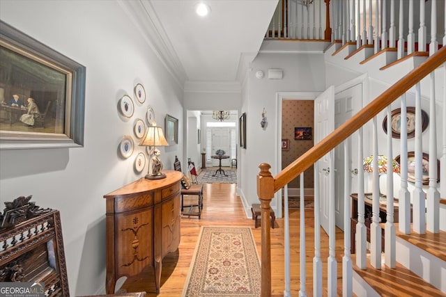 entrance foyer featuring crown molding and light hardwood / wood-style floors