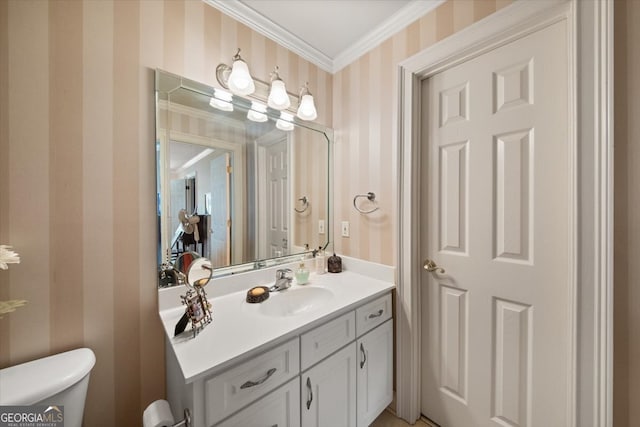 bathroom with ornamental molding, vanity, and toilet