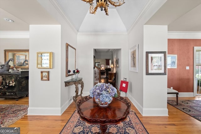 foyer entrance featuring light hardwood / wood-style flooring, ornamental molding, and lofted ceiling