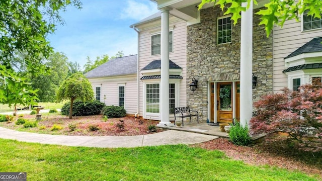 doorway to property featuring a lawn