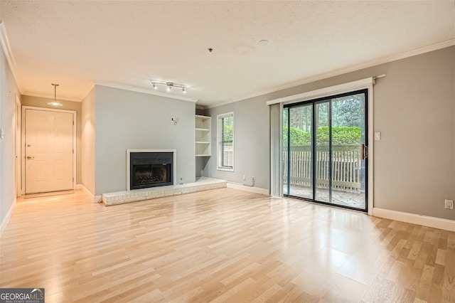 unfurnished living room with a textured ceiling, built in shelves, crown molding, and light wood-type flooring