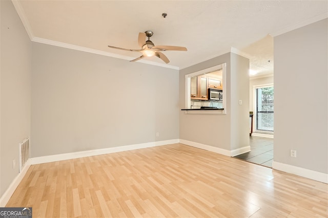 unfurnished living room with ceiling fan, ornamental molding, and light hardwood / wood-style flooring