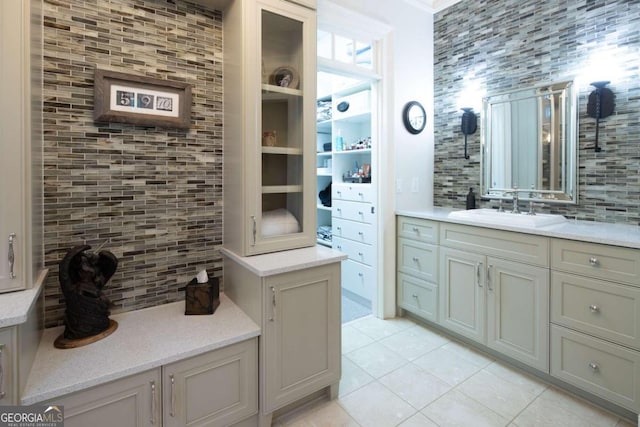 bathroom with tile patterned flooring, vanity, and backsplash