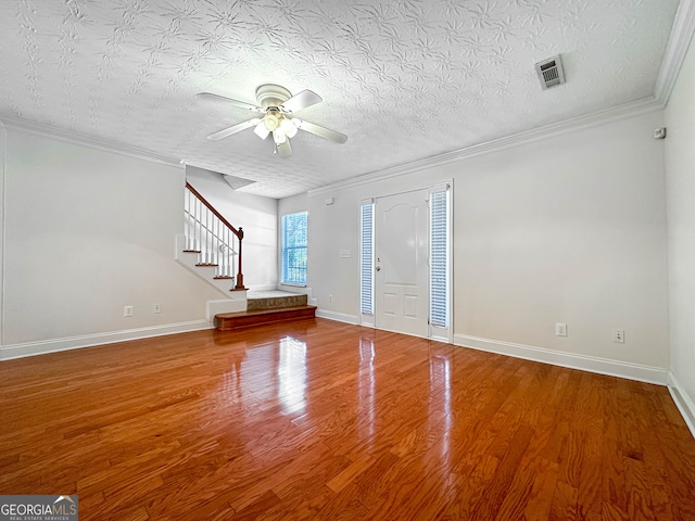 foyer entrance with hardwood / wood-style flooring, a textured ceiling, crown molding, and ceiling fan