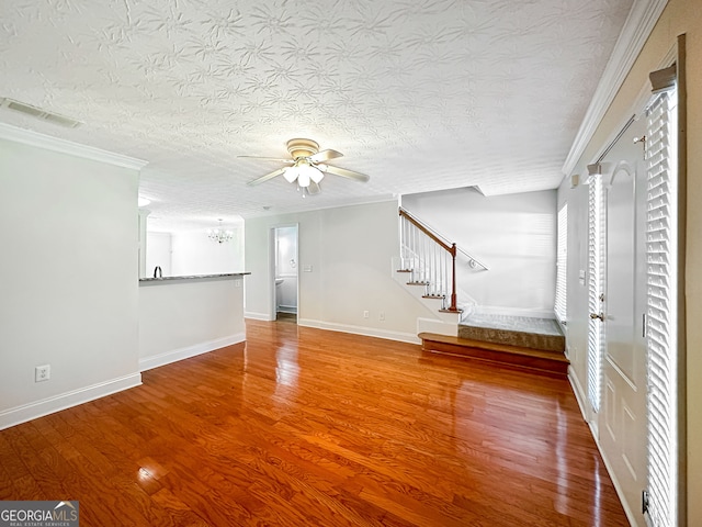 unfurnished living room with ornamental molding, ceiling fan, hardwood / wood-style floors, and a textured ceiling