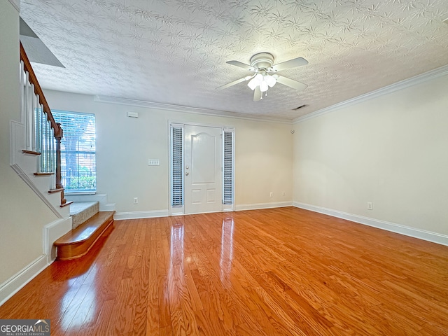 foyer entrance featuring ornamental molding, a textured ceiling, ceiling fan, and hardwood / wood-style floors