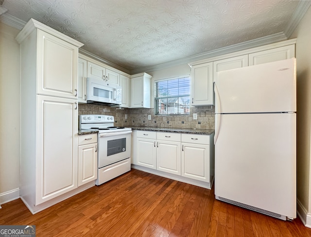 kitchen with white appliances, decorative backsplash, white cabinetry, wood-type flooring, and ornamental molding