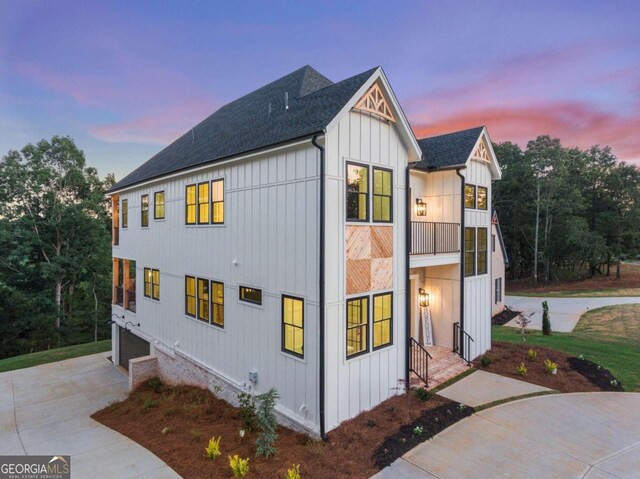 property exterior at dusk featuring a balcony