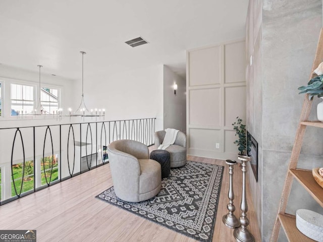 living area with light hardwood / wood-style floors and a notable chandelier