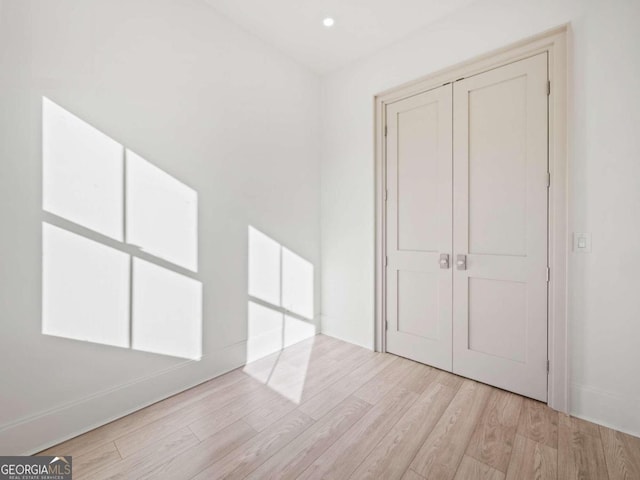 unfurnished bedroom featuring light hardwood / wood-style floors and a closet