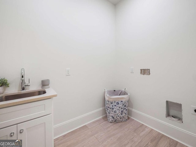 laundry area featuring light hardwood / wood-style floors, sink, cabinets, and hookup for an electric dryer